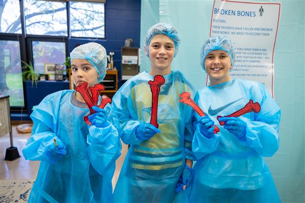 three students in scrubs smiling